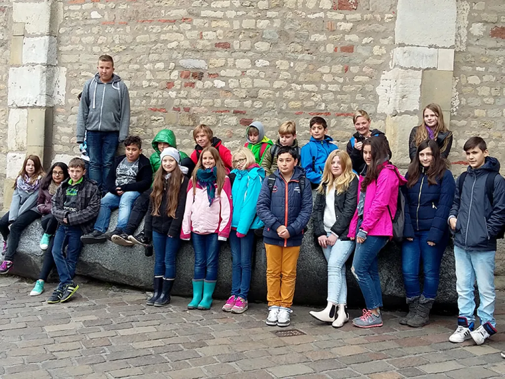 Klassenfoto auf einer Mauer vor dem Dom.